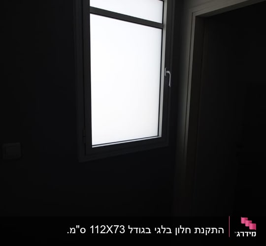 חלון עם מסגרת אלומיניום וקיר כהה